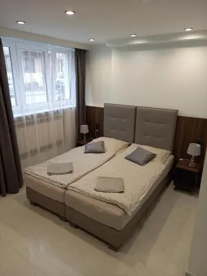 a bedroom with a large bed with two pillows at Mini Apartamenty Kraków in Kraków