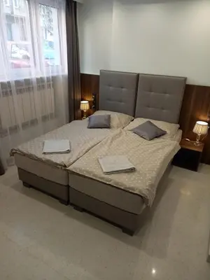 a bedroom with a large bed with two pillows at Mini Apartamenty Kraków in Kraków