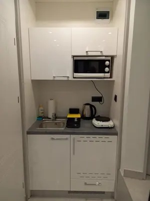 a small kitchen with a sink and a microwave at Mini Apartamenty Kraków in Kraków