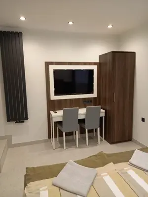 a living room with a table with two chairs and a television at Mini Apartamenty Kraków in Kraków
