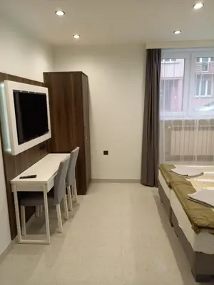 a room with a table and a bed and a television at Mini Apartamenty Kraków in Kraków