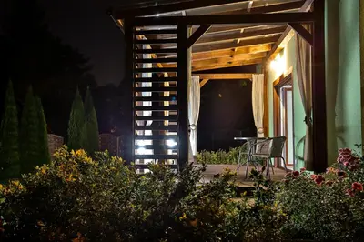 a chair sitting on a porch at night at Apartament Zielona Willa in Skomielna Biała