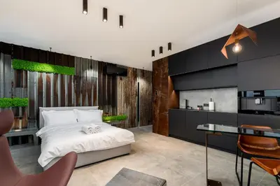 a bedroom with a bed and a kitchen at Wiślane Tarasy - UNIQUE Apartments 4YOU - 10 piętro z pięknym widokiem na centrum Krakowa in Kraków