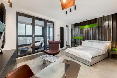 a bedroom with a bed and a desk and a chair at Wiślane Tarasy - UNIQUE Apartments 4YOU - 10 piętro z pięknym widokiem na centrum Krakowa in Kraków