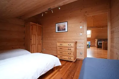 a bedroom with two beds and a wooden wall at Chata Palarówka in Grzechynia