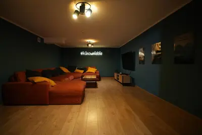 a living room with a couch and a television at Chata Palarówka in Grzechynia