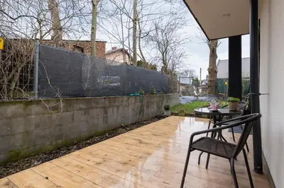 a patio with a table and a chair next to a fence at Apartment in Krakow with parking and balcony by Noclegi Renters in Modlnica