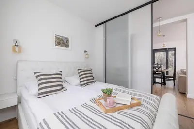 a bedroom with a white bed with a tray on it at Apartment in Krakow with parking and balcony by Noclegi Renters in Modlnica