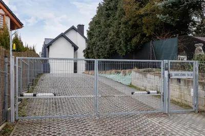 a gate in front of a driveway in front of a house at Apartment in Krakow with parking and balcony by Noclegi Renters in Modlnica