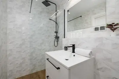 a white bathroom with a sink and a shower at Apartment in Krakow with parking and balcony by Noclegi Renters in Modlnica
