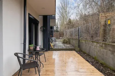 a patio with a table and chair and a fence at Apartment in Krakow with parking and balcony by Noclegi Renters in Modlnica