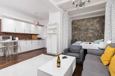 a living room and kitchen with a couch and a table at Lux Studio City Center Sołtyka by Noclegi Renters in Kraków