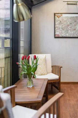 a table with a vase of red flowers on it at Lux Studio City Center Sołtyka by Noclegi Renters in Kraków