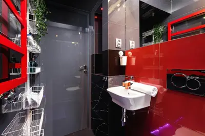 a bathroom with a sink and a red wall at Lux Studio City Center Sołtyka by Noclegi Renters in Kraków