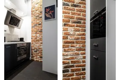 a kitchen with a brick wall and an oven at Househost Apartment: Józefa 2/10 in Kraków