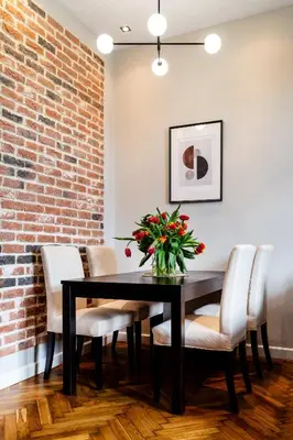 a dining room with a black table and chairs and a brick wall at Househost Apartment: Józefa 2/10 in Kraków