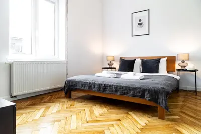a bedroom with a bed and a wooden floor at Househost Apartment: Józefa 2/10 in Kraków