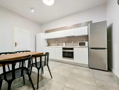 a kitchen with a table and a refrigerator at Paulińska 18 by Homeprime in Kraków