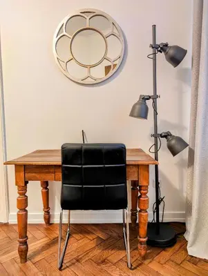 a desk with a black chair and a mirror at Paulińska 18 by Homeprime in Kraków