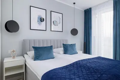 a bedroom with a blue and white bed with blue pillows at Unique Apartment with Balcony & Parking Zabłocie Cracow by Renters Prestige in Kraków