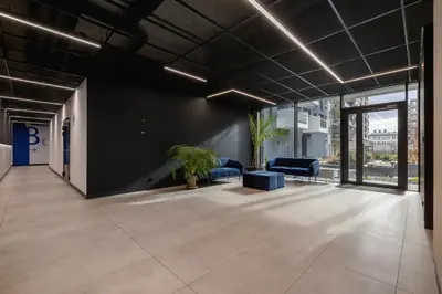 an empty office lobby with blue chairs and plants at Unique Apartment with Balcony & Parking Zabłocie Cracow by Renters Prestige in Kraków