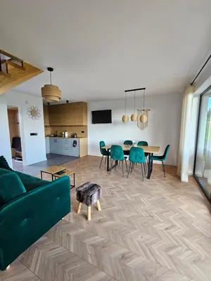 a living room with a green couch and a table at Okno Na Góry in Klikuszowa