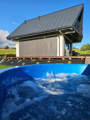 a house with a pool of water in front of it at Okno Na Góry in Klikuszowa