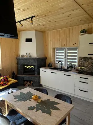 a kitchen with a table and a fireplace at Domek nad Poniczanką in Rabka-Zdroj