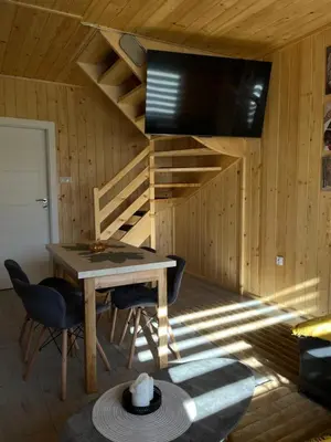 a dining room with a table and a tv in a cabin at Domek nad Poniczanką in Rabka-Zdroj