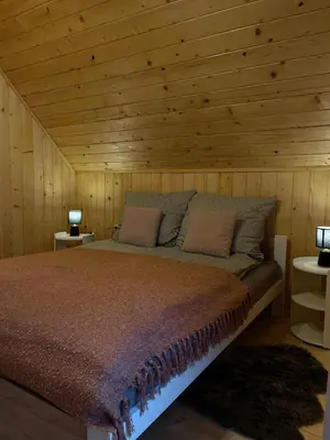 a bedroom with a bed in a wooden cabin at Domek nad Poniczanką in Rabka-Zdroj