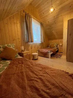 a room with two beds in a log cabin at Domek nad Poniczanką in Rabka-Zdroj
