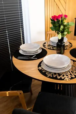 a table with plates and a vase of flowers on it at DOMKI NA LUZIE w górach PREMIUM , dla dorosłych i młodzieży in Spytkowice