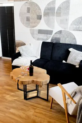 a living room with a black couch and a table at DOMKI NA LUZIE w górach PREMIUM , dla dorosłych i młodzieży in Spytkowice