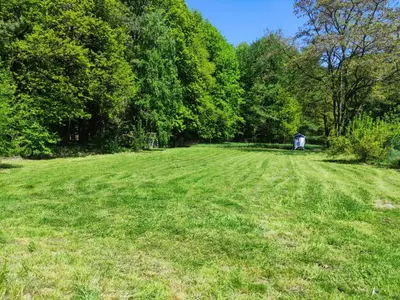 a large grass field with a building in the distance at PrzyTuLasek - domek pod lasem w sercu natury, blisko Energylandii in Zator