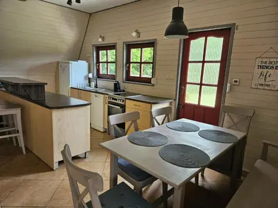 a kitchen with a table and chairs in a kitchen at PrzyTuLasek - domek pod lasem w sercu natury, blisko Energylandii in Zator