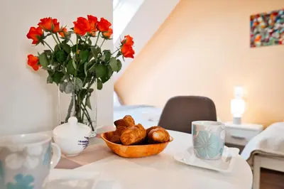 a table with a bowl of bread and a vase with flowers at Studio D&D Przeciszów in Przeciszów