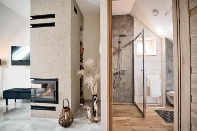 a living room with a fireplace and a glass shower at Studio D&D Przeciszów in Przeciszów