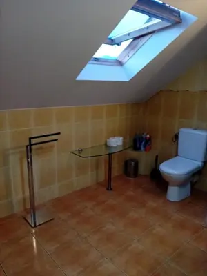 a bathroom with a toilet and a glass table at Orkana44F in Mszana Dolna