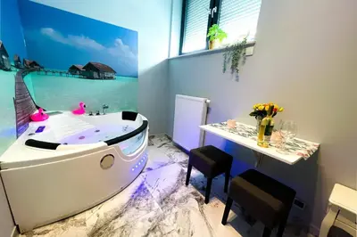 a bathroom with a bath tub with a table and chairs at Hot Jacuzzi in Cracow in Kraków