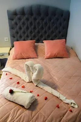 a bed with red rose petals on it at Hot Jacuzzi in Cracow in Kraków