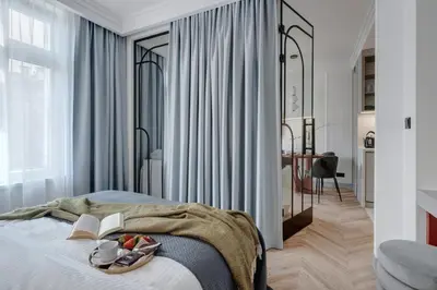 a bedroom with a bed with books and a mirror at MameHome Apartments in Kraków