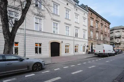 a car parked on a street next to a white building at MameHome Apartments in Kraków