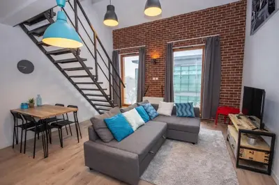 a living room with a couch and a brick wall at InPoint Modern Loft - City Centre Łazarza St 13 Self Check-in in Kraków