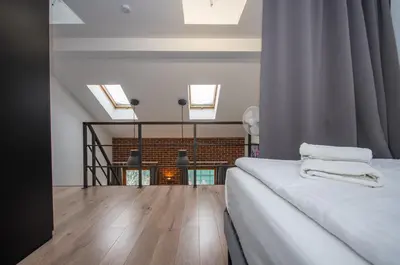 a bedroom with a bed and a living room at InPoint Modern Loft - City Centre Łazarza St 13 Self Check-in in Kraków