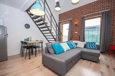 a living room with a couch and a brick wall at InPoint Modern Loft - City Centre Łazarza St 13 Self Check-in in Kraków