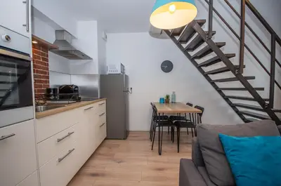 a kitchen with a staircase and a table with chairs at InPoint Modern Loft - City Centre Łazarza St 13 Self Check-in in Kraków