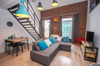 a living room with a couch and a brick wall at InPoint Modern Loft - City Centre Łazarza St 13 Self Check-in in Kraków