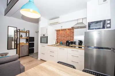 a kitchen with white cabinets and a stainless steel refrigerator at InPoint Modern Loft - City Centre Łazarza St 13 Self Check-in in Kraków