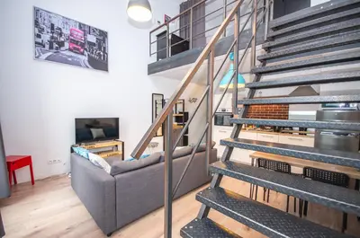 a living room with a staircase with a couch at InPoint Modern Loft - City Centre Łazarza St 13 Self Check-in in Kraków