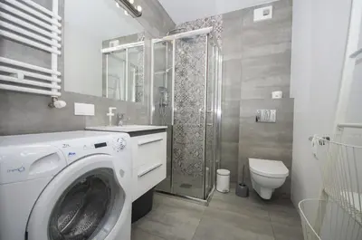 a bathroom with a washing machine and a shower at InPoint Modern Loft - City Centre Łazarza St 13 Self Check-in in Kraków